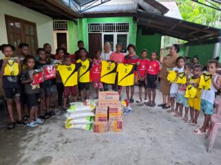 Sekwan DPR Papua, Juliana Waromi saat menyerahkan bantuan kostum bola dan bahan pangan di Gereja Santo Petrus Koya Tengah / rbt
