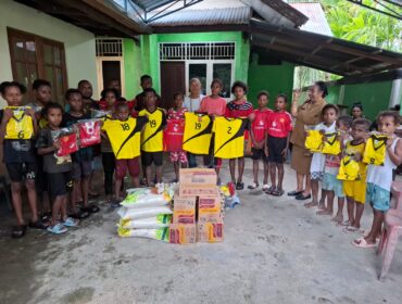 Sekwan DPR Papua, Juliana Waromi saat menyerahkan bantuan kostum bola dan bahan pangan di Gereja Santo Petrus Koya Tengah / rbt