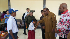 Seorang siswa bersalaman dengan Asisten 1 Setda Papua, Yohanes Walilo / Papua.go.id