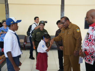 Seorang siswa bersalaman dengan Asisten 1 Setda Papua, Yohanes Walilo / Papua.go.id