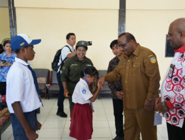 Seorang siswa bersalaman dengan Asisten 1 Setda Papua, Yohanes Walilo / Papua.go.id