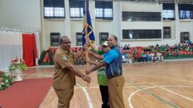 Asisten I Setda Papua, Yohanes Walilo menyerahkan pataka kepada kontingen Popnas dan Peparpenas