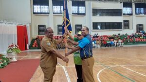 Asisten I Setda Papua, Yohanes Walilo menyerahkan pataka kepada kontingen Popnas dan Peparpenas 