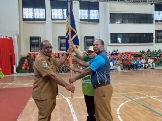 Asisten I Setda Papua, Yohanes Walilo menyerahkan pataka kepada kontingen Popnas dan Peparpenas 