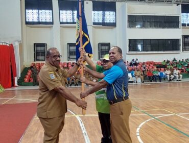 Asisten I Setda Papua, Yohanes Walilo menyerahkan pataka kepada kontingen Popnas dan Peparpenas 