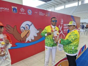Ketua NPCI Papua, H. Jayakusuma usai menyerahkan medali emas kepada atlet renang Papua, De Jhon Waromi 