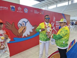 Ketua NPCI Papua, H. Jayakusuma usai menyerahkan medali emas kepada atlet renang Papua, De Jhon Waromi 