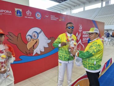 Ketua NPCI Papua, H. Jayakusuma usai menyerahkan medali emas kepada atlet renang Papua, De Jhon Waromi 