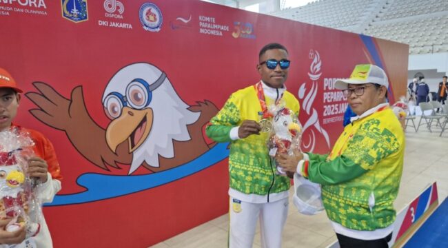 Ketua NPCI Papua, H. Jayakusuma usai menyerahkan medali emas kepada atlet renang Papua, De Jhon Waromi 