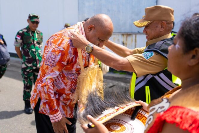 
					Gubernur Papua, Matius D. Fakhiri dikalungkan noken oleh Bupati Biak, Markus Mansnembra / Istimewa