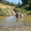 Tampak personil Polres Keerom Briptu Muflihuddin dan Bripda Rian Merahabia ketika menyeberangi sungai ketika melakukan pengawalan logistik Pemilu 2024 menuju Kampung Milki, Distrik Towe, Keerom pada 15 Februari 2024 silam / Istimewa